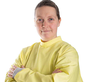 Woman with yellow medical covering with arms crossed