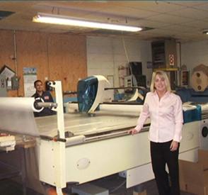 Woman standing next to a table with a cutting tool